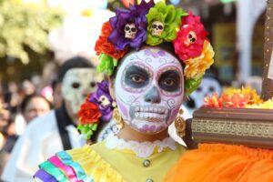 Catrina with colorful floral crown and traditional Día de los Muertos face paint at San Antonio Market Square