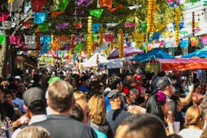 Crowd beneath colorful papel picado decorations at Historic Market Square in San Antonio