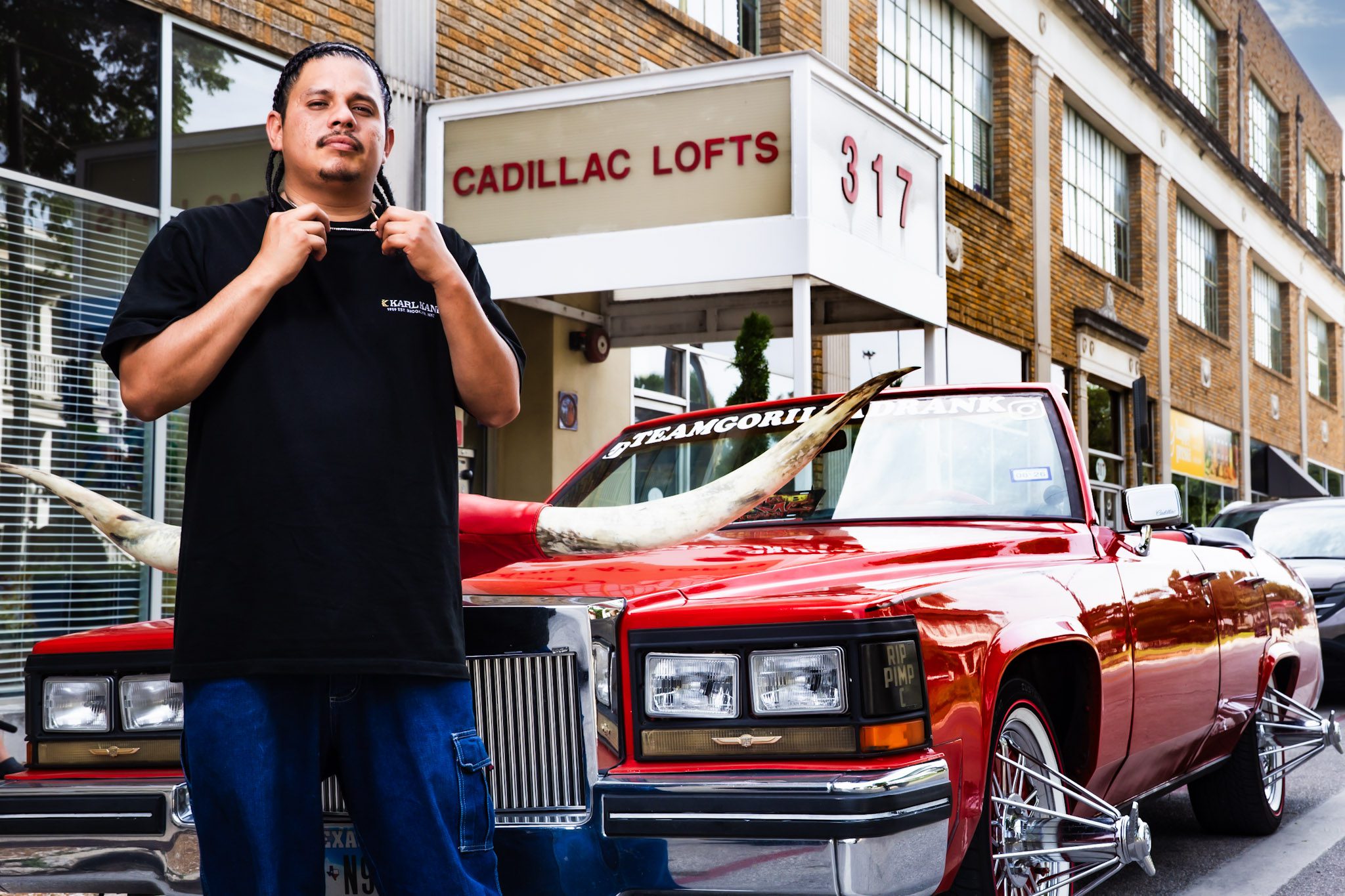 Lil Lucky beside a red convertible in San Antonio